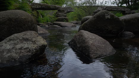 Puente-Con-El-Río-Debajo-Mientras-La-Cámara-Se-Inclina-Lentamente-Hacia-Arriba,-En-El-Parque-Nacional-De-Dartmoor,-Inglaterra