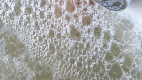 closeup of bubbles in the hot tub. through soap bubbles visible legs resting person. the concept of rest and recreation