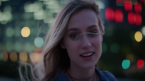 close-up-portrait-beautiful-young-blonde-woman-looking-at-city-lights-turns-head-smiling-confident-enjoying-urban-night-life-wind-blowing-hair-carefree-independent-female