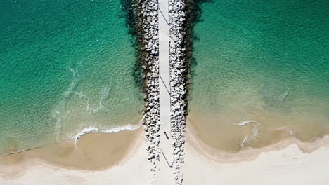 aerial footage of portugal's clear atlantic waters, flying over the trestle bridge