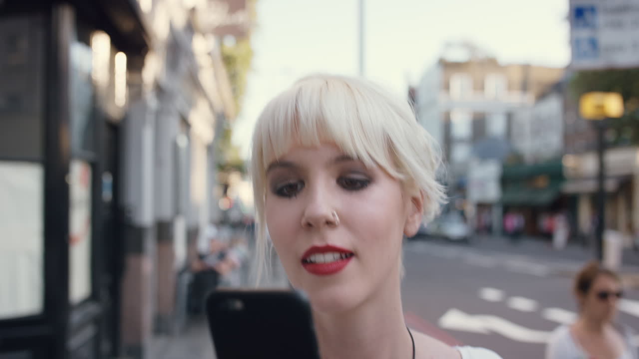 도시에서 스마트 폰을 사용하는 아름다운 금발