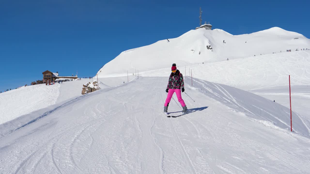 초보 스키 선수 여자 조심스럽게 그리고 산의 스키 경사에서 스키를 느리게