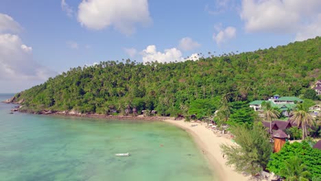 drone aéreo de 4k hacia abajo y hacia adelante de la playa de ensalada en koh phangan en tailandia con barcos de pesca, agua verde azulado, coral y selvas verdes