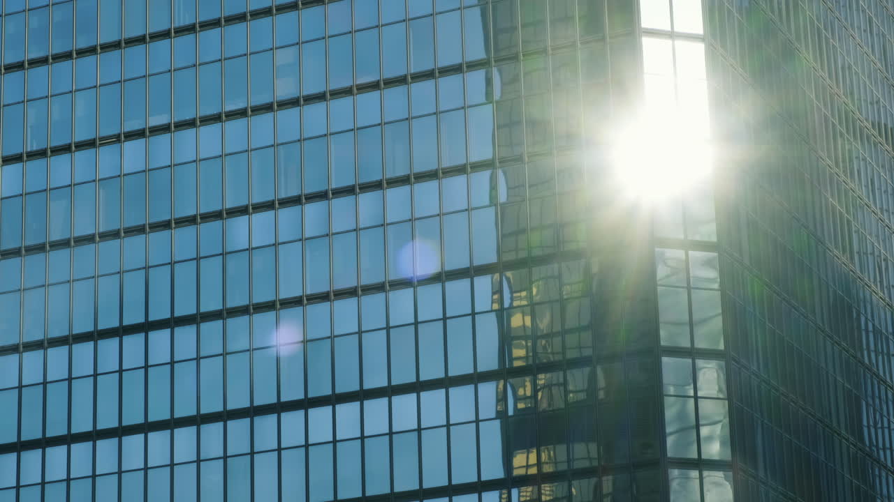 태양 광선을 반사하는 유리와 강철 벽을 갖춘 현대적인 비즈니스 아키텍처