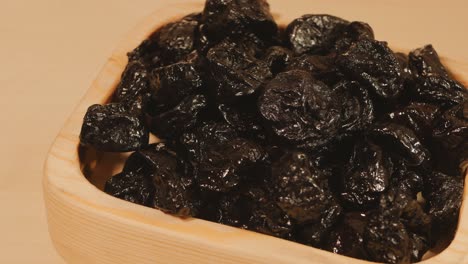 dried fruits prunes rotate in a wooden plate. top view. close-up. 4k