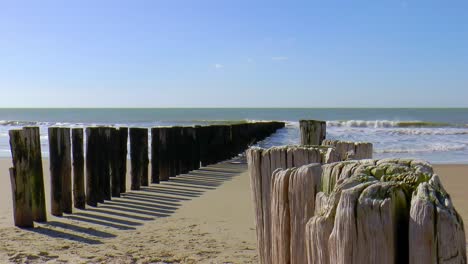 breakwater on the beach, blue sky, the sea in slow motion without people