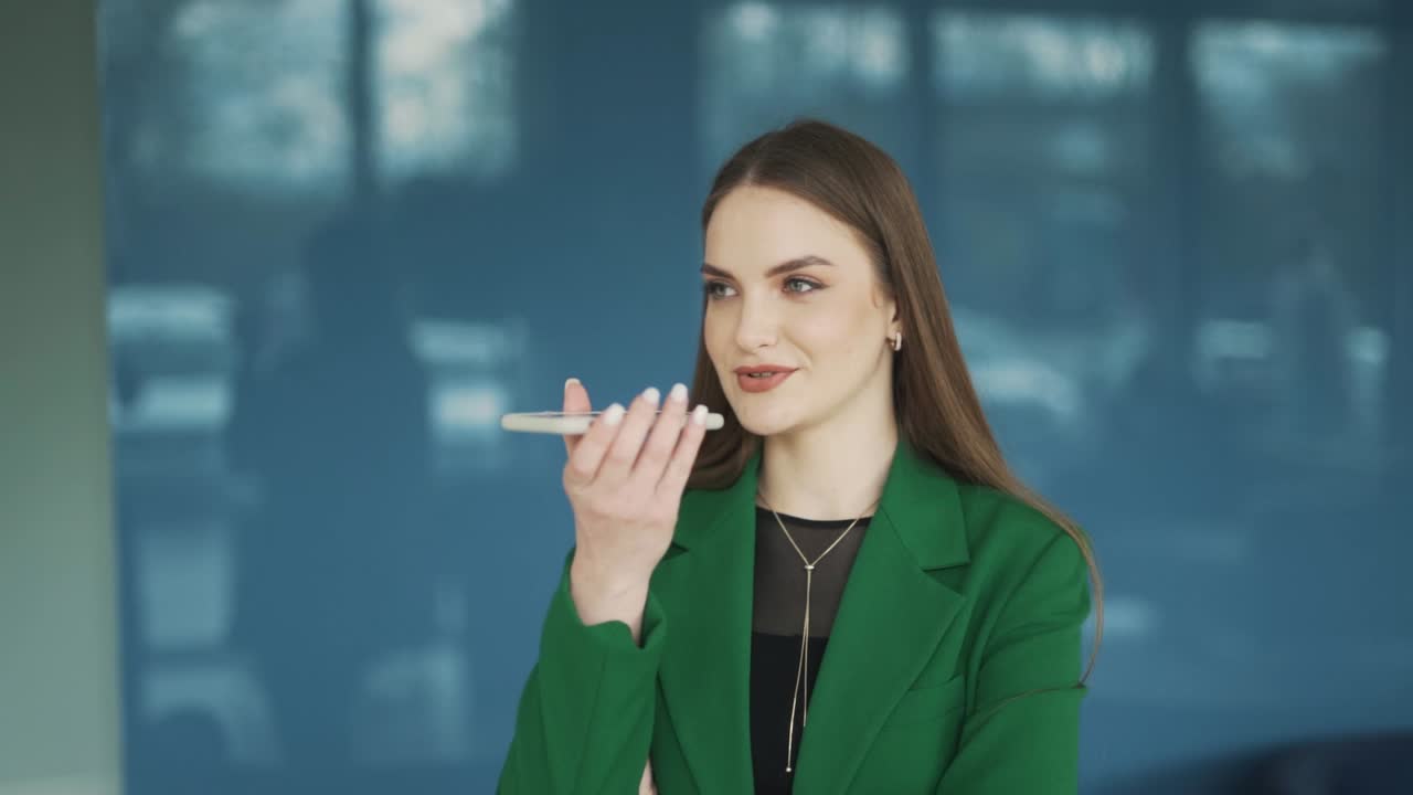 hermosa mujer con ropa profesional graba un mensaje de voz en su teléfono inteligente
