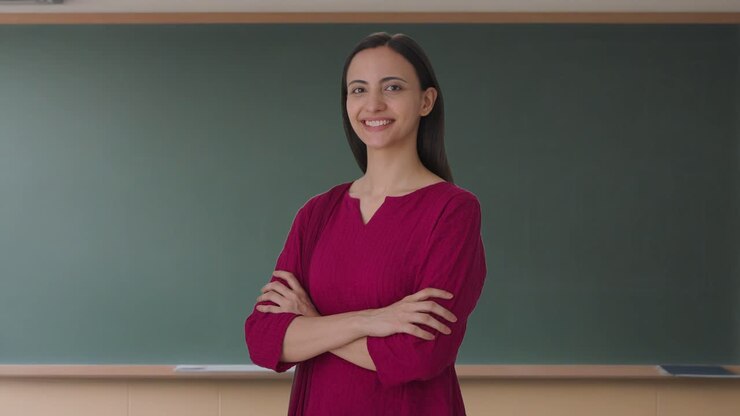 retrato de una feliz profesora india de pie con las manos cruzadas