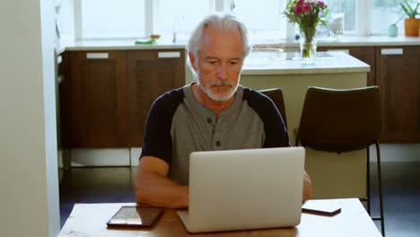 Senior-man-using-laptop-on-table-4k
