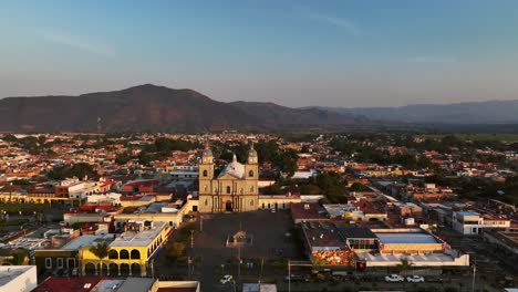 Vista-Aérea-De-La-Ciudad-Y-El-Municipio-De-Tuxpan-Con-La-Catedral-Al-Atardecer-En-Jalisco,-México---Tiro-Con-Drones