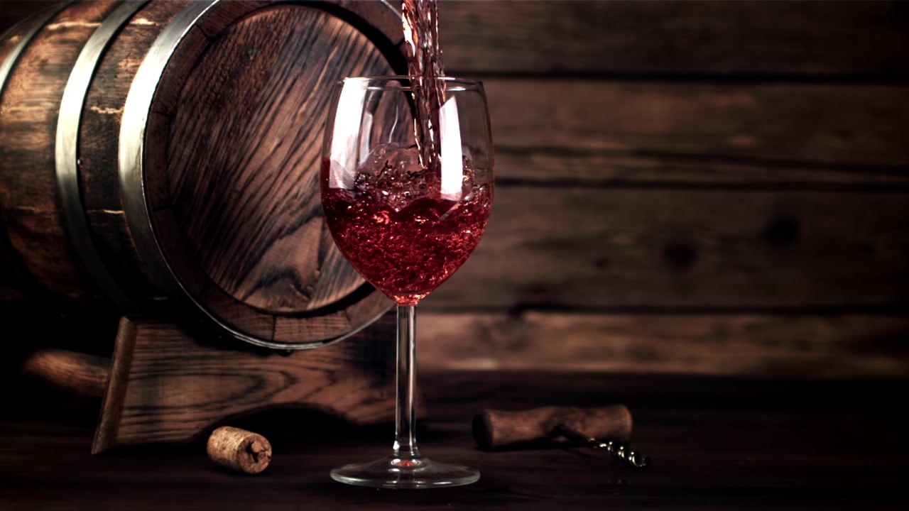 Slow Motion Pour of Red Wine into a Glass by a Barrel