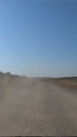 off road vehicle driving through the los monegros desert in spain in vertical