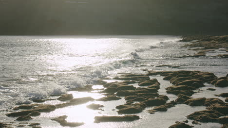 Costa-De-Lanzarote-Con-Olas-Del-Océano-Lavando-Piedras-Volcánicas-Escena-Bajo-La-Luz-Del-Sol