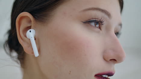 closeup beautiful woman face with wireless earbuds in ears. gorgeous young girl.