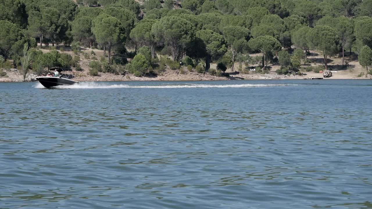 Two speed boat crossing lake pantano de San Juan, Madrid