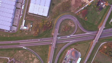 Aerial-Shot-of-Industrial-Warehouse-Storage-Building-Loading-Area-where-Many-Trucks-Are-Loading-Unloading-Merchandise