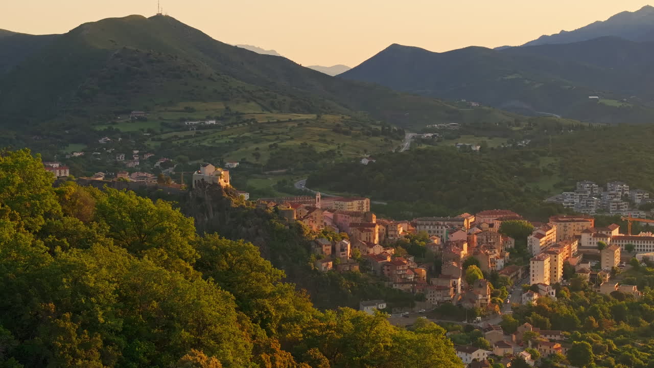 Early morning, sunrise. Aerial view of the Old town of Corte in Corsica, France. First lights, golden hour. View of the scenic mountainous landscape valley