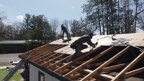 home building construction workers installing roof sheathing on new home rooftop