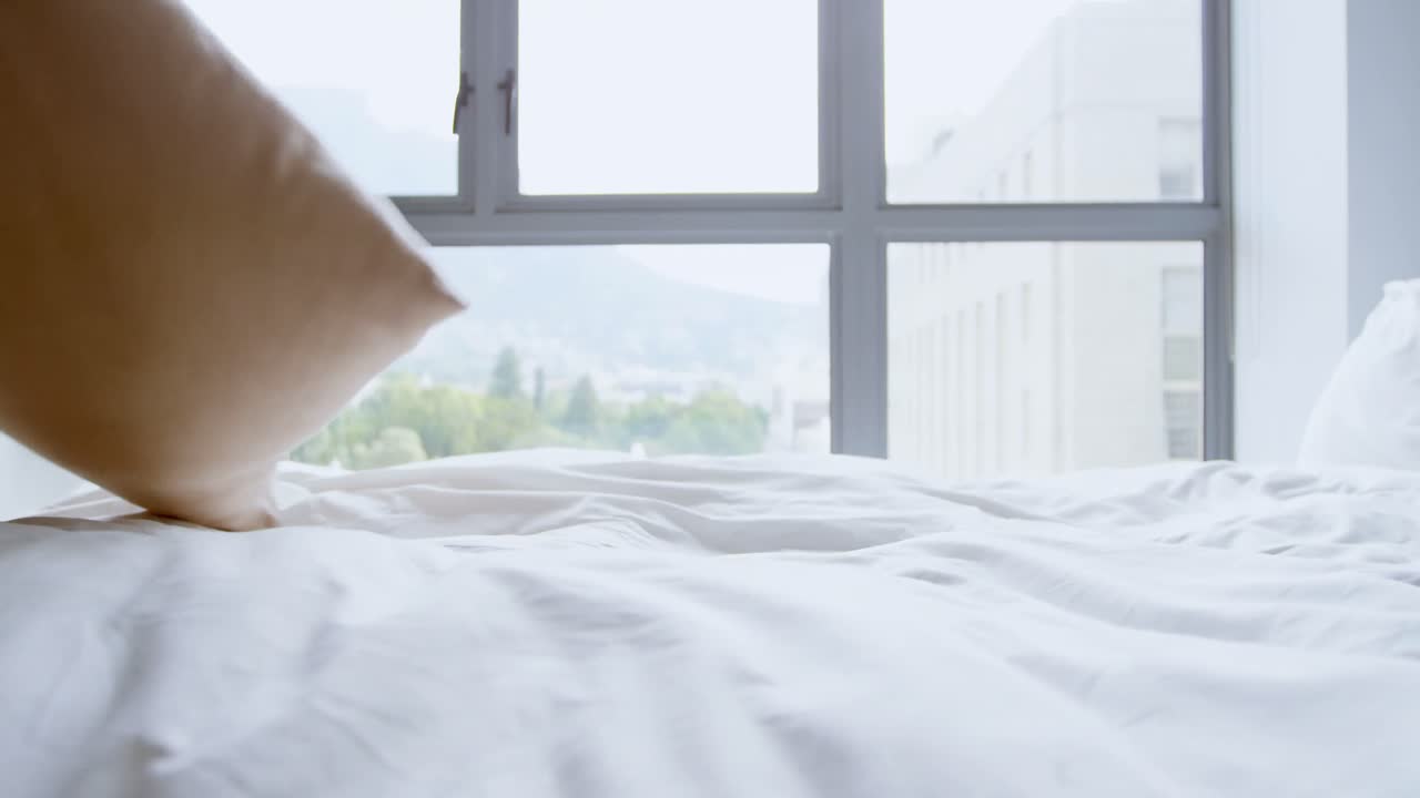 침실 4k에서 베개를 들고 있는 여자