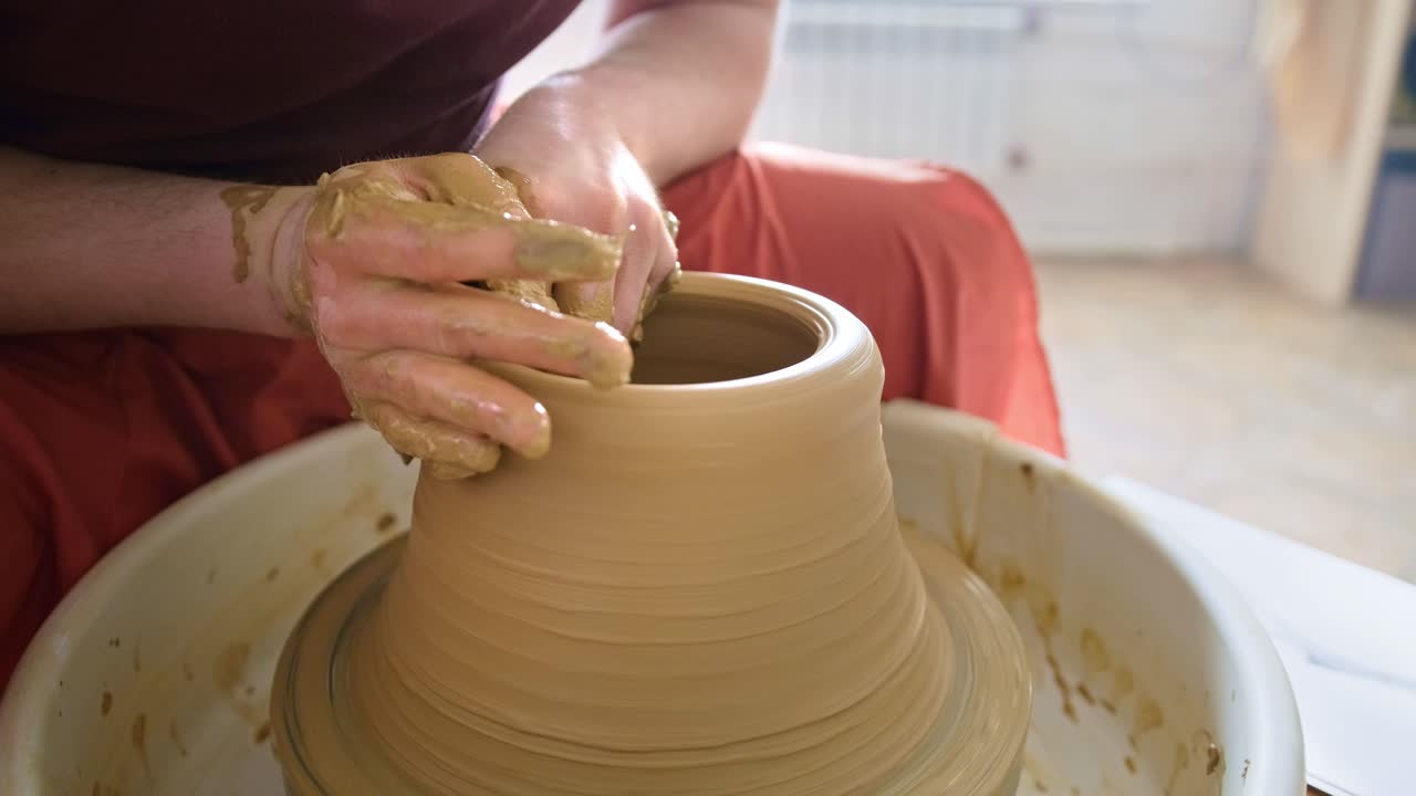 persona que da forma a la arcilla en la rueda de la cerámica