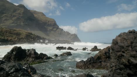 rocas volcánicas afiladas en movimiento lento, olas del océano aplastantes cerca de punta negra, buenavista del norte, tenerife, islas canarias en primavera