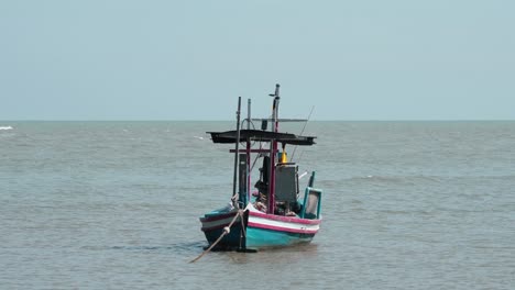 Barco-Pesquero-Amarrado-En-La-Tarde-Mientras-Su-Techo-Se-Ve-Debajo-Del-Horizonte-Del-Océano-Mientras-Se-Mueve-Con-El-Viento-En-El-Parque-Nacional-Khao-Sam-Roi-Yot,-Phrachuap-Khiri-Khan,-Tailandia