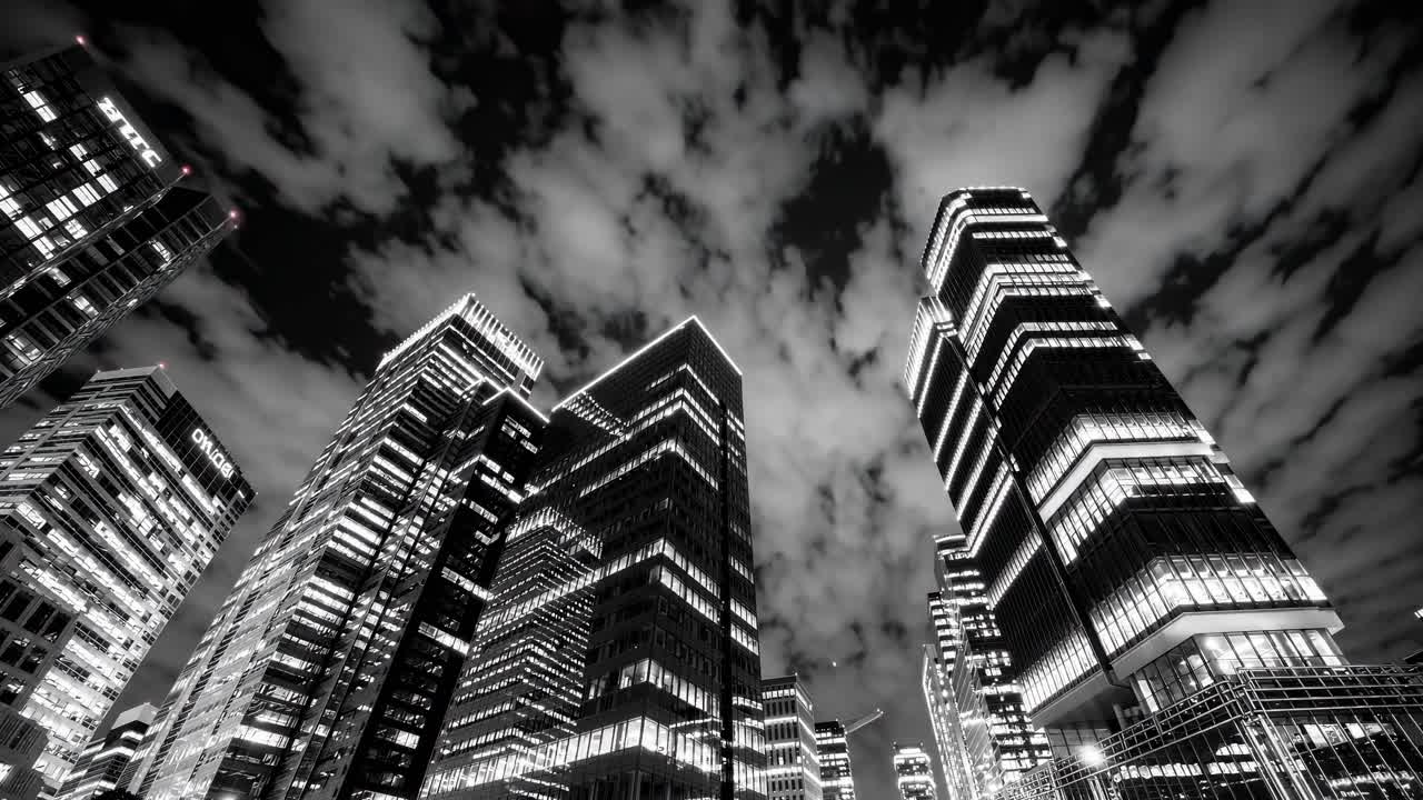 Dramatic low-angle black and white cityscape captures towering skyscrapers against a moody sky