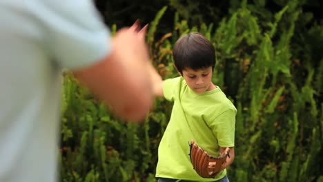 young boy playing baseball with his father