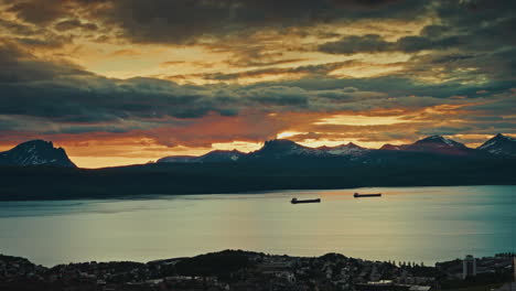 static shot of the midnight sunset over the norwegian fjords in narvik.
view of the dramatic traveling clouds at golden hour. picturesque nordic landscape.