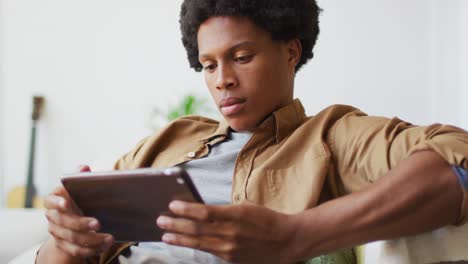 Happy-african-american-man-using-tablet-at-home