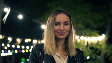 Retrato-De-Una-Hermosa-Chica-Con-Una-Chaqueta-De-Cuero-Negra-Y-Una-Blusa-Blanca-Parada-En-El-Parque-Nocturno