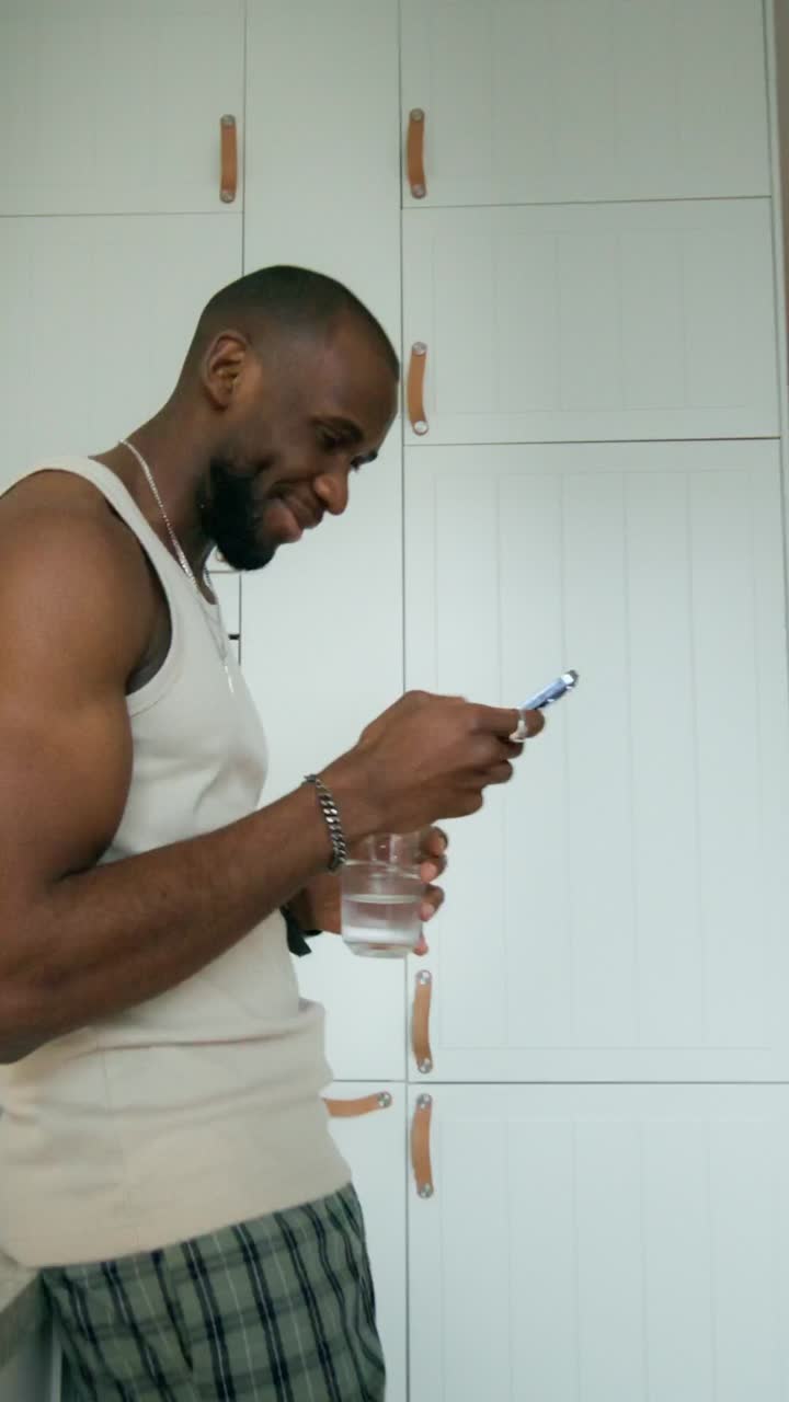 Man using phone in a modern kitchen