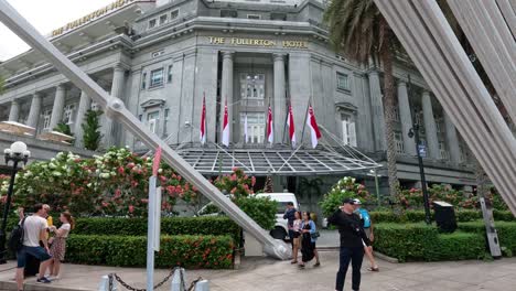 people walking and taking photos outside a grand building.