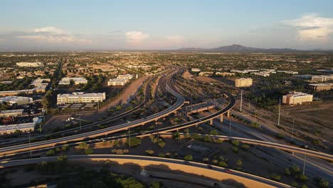 4k aerial view of busy traffic on a interchange in arizona, road junction of highway 101 and 202 in the late evening