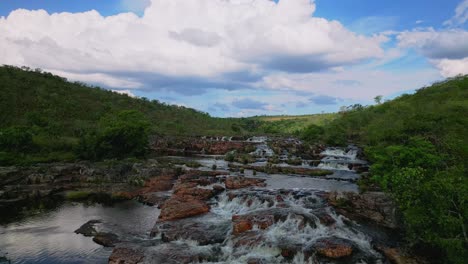 impresionante vista aérea de las cataratas dos couros cascada por un lecho rocoso del río en el exuberante paisaje del parque nacional de chapada dos veadeiros, goias, brasil, drone sobrevuela