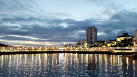 Abend-In-Der-Stadt-Ponta-Delgada-Mit-Lichtern,-Die-Sich-Vor-Einbruch-Der-Nacht-Im-Wasser-Spiegeln