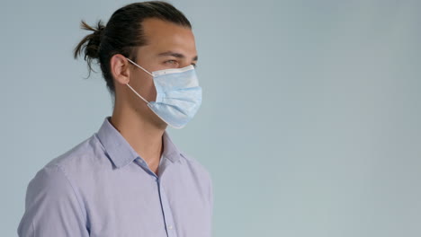 Close-up-of-brunette-man-putting-on-hygienic-mask