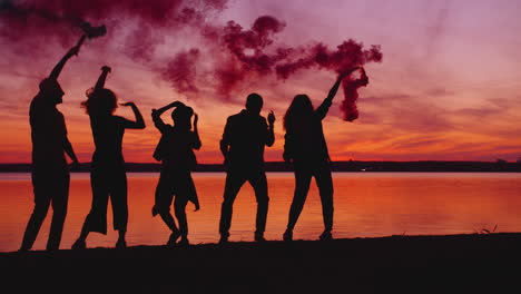 friends celebrating sunset by the lake