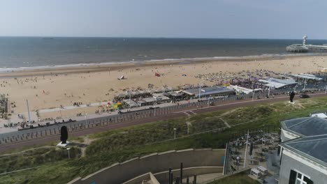 Drone-Slowmotion-of-Scheveningen-Beach-with-the-Pier-in-the-Background-during-Hot-Weather