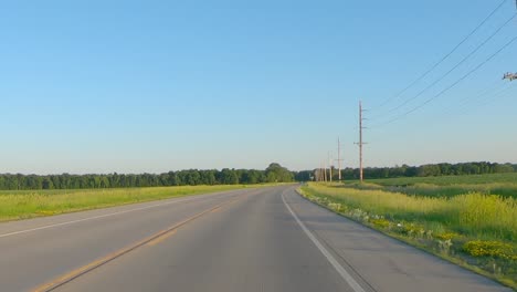 pov while driving on a rural county road thru the midwest on a late spring afternoon