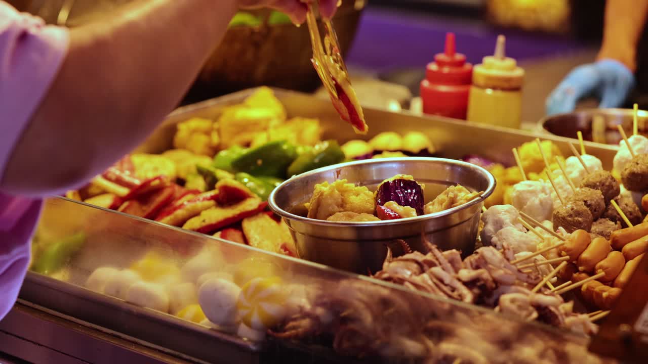 vendedor preparando salchichas en un puesto de comida