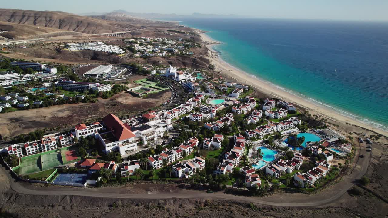 Località balneare a Fuerteventura con hotel, piscine e l'oceano, vista aerea