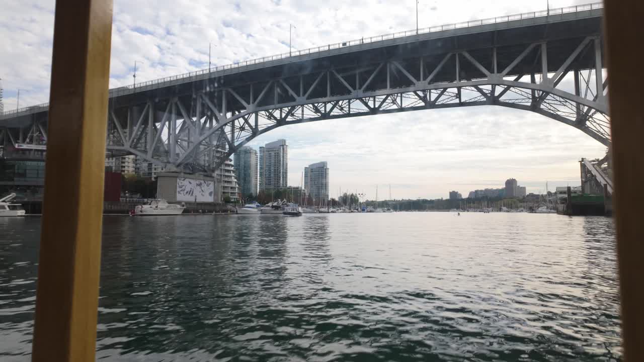 Boat POV shot traveling underneath the Granville Bridge on the False Creek Ferry in Vancouver, British Columbia, Canada. 4K