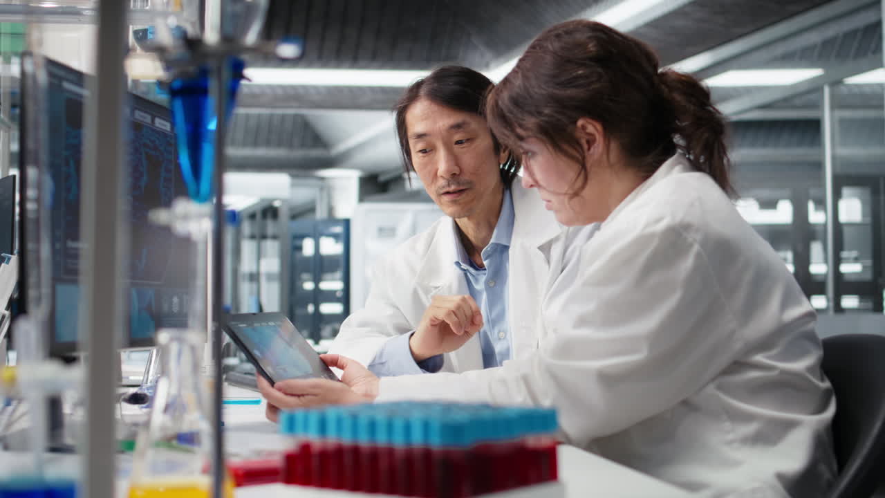 Vertical video Laboratory manager and trainee using tablet app to process DNA patient data