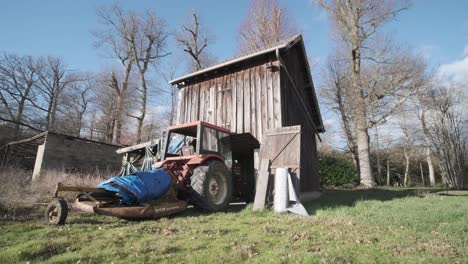 viejo tractor frente a un granero