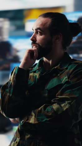 vertical video male army officer operates from a mission command center with digital tech