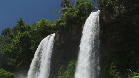 iguazu falls waterfalls in argentina, bright sunny south america weather conditions with beautiful jungle waterfall, two large slow motion waterfalls, panning down view of iguacu falls