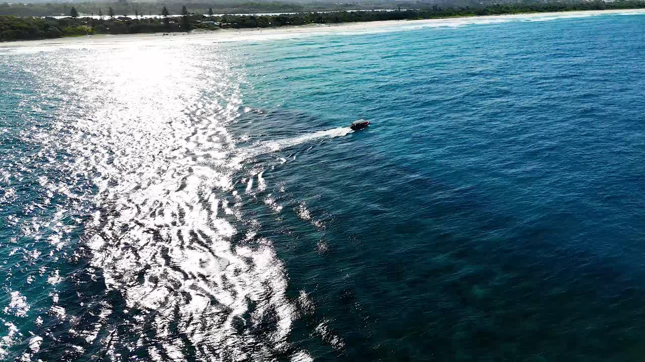 un barco viaja a través de las aguas del océano iluminadas por el sol