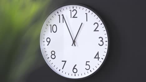 simple clock hanging on black wall close up