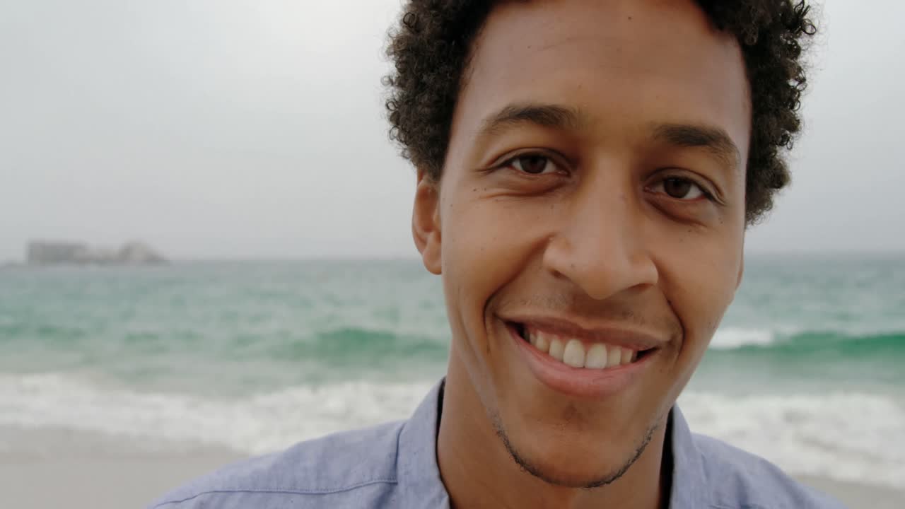 Front view of African American man standing on the beach 4k